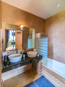 baño con 2 lavabos y espejo grande en Villa de luxe service compris en Marrakech