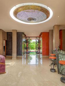 un gran vestíbulo con techo y lámpara de araña en Villa de luxe service compris en Marrakech