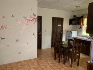 a kitchen with a table with butterflies on the wall at Linda Vista Cabins in Boquete