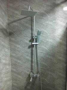 a shower stall with a shower head and a shower at Charming & Cozy 1-BDR Apt - Mini Flat - 247 Power, Kitchen, Wi-Fi, DSTV, Netflix, 5 mins from the Airports in Ikeja