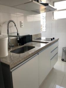 a kitchen with a sink and a counter top at Apartamento encantador no Gonzaguinha! Todo Reformado!! Completo! in São Vicente