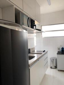 a kitchen with a stainless steel refrigerator and a sink at Apartamento encantador no Gonzaguinha! Todo Reformado!! Completo! in São Vicente