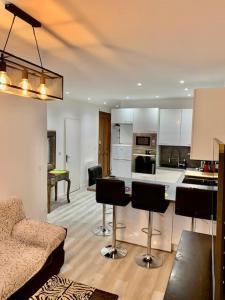 een woonkamer met een keuken met barkrukken bij Gold Europole-Gare in Grenoble