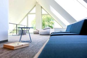 Un dormitorio con una cama azul y una mesa. en Exklusives Landhaus auf Fehmarn, en Schlagsdorf