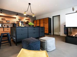 a living room with a kitchen and a tv at Exklusives Landhaus auf Fehmarn in Schlagsdorf