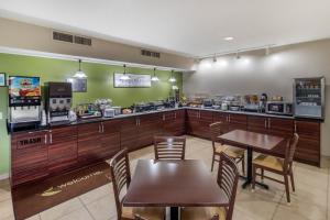 a restaurant with a table and chairs and a counter at Sleep Inn & Suites Allendale in Allendale