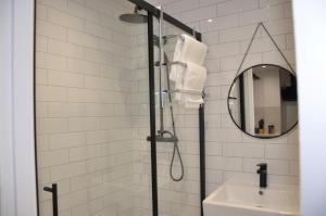 a bathroom with a shower with a sink and a mirror at Luxury Studio- MK central- 5 MINS DRIVE TO TRAIN STATION-DIRECT TRAINS TO LONDON, BIRMINGHAM in Milton Keynes