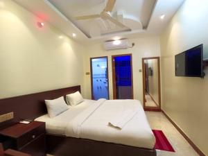 ein Schlafzimmer mit einem großen Bett und einem TV in der Unterkunft Sea Front Resort in Cox's Bazar