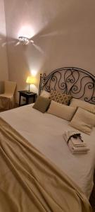 een slaapkamer met een groot wit bed met een zwart hoofdeinde bij I Balconi sul Duomo in Lecce