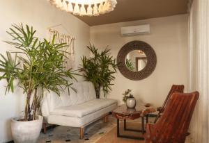 a living room with a white couch and a mirror at Hotel Scappata in Progreso