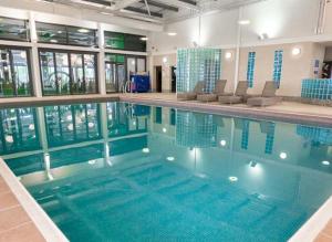 uma grande piscina com água azul num edifício em Hot tub breaks Fairways Tattershall lakes em Tattershall