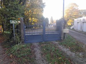 a blue gate on the side of a road at location petit gite individuel in Orgères +6 photos