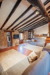 an attic bedroom with two beds and a fireplace at Casa Rural El Callís in Vall de Bianya