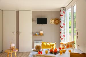 a living room with a table with oranges on it at Camping Moulin de Paulhiac in Daglan