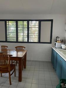 a kitchen with a wooden table and chairs and a table and a counter at Hébergement tout équipé et surveillance H24 in Koungou