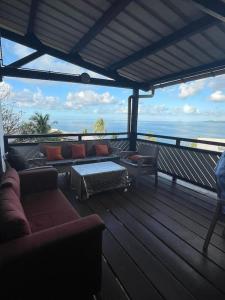 eine Terrasse mit Sofas und einem Tisch sowie Meerblick in der Unterkunft Hébergement tout équipé et surveillance H24 in Koungou