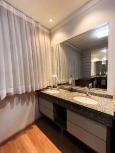 a bathroom with two sinks and a large mirror at Goldmen Business Hotel in Cianorte