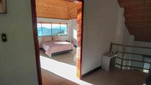 a bedroom with a bed and a large window at El Cerezo Casa de campo in Tópaga