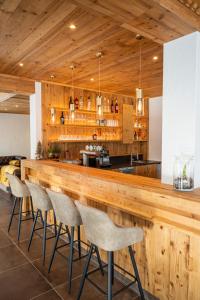 a kitchen with a wooden bar with stools at Hotel Haus Lungau in Mauterndorf