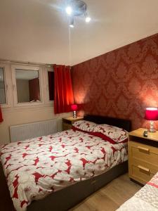 a bedroom with a bed and a red wall at City Central Apartments - above Victoria Centre Shopping Centre - most Central Location on Milton Street next to the Hilton Hotel - Apartments with up to 4 Beds - Cook as you would at Home - Outdoor Parking for Cars or Vans at five pounds a day in Nottingham