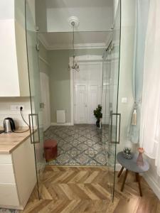 a glass shower in a kitchen with a table at PJ apartment in Budapest