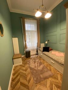 PJ apartment في بودابست: غرفة نوم بجدران خضراء وسرير ونافذة