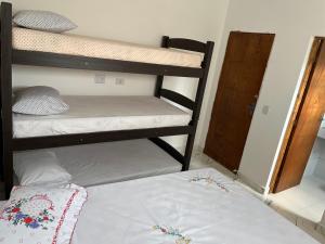 a bedroom with two bunk beds and a bed at Casa com piscina Guarujá Praia Pernambuco,Mar Casado in Guarujá