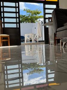 a table with chairs and a reflection of the sky at Guarujá Praia de Pernambuco in Guarujá