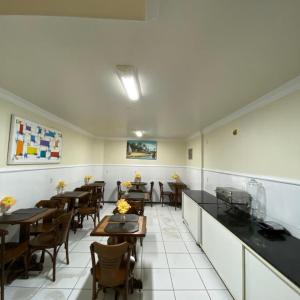 a restaurant with tables and chairs in a room at Hotel Monte Rei in Salvador