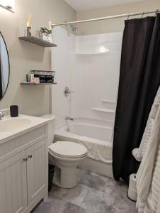 y baño con aseo, bañera y lavamanos. en Comfy Champaign 3 Bedroom House, en Champaign