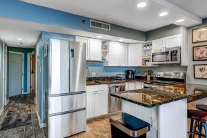 een keuken met witte kasten en een koelkast bij Ocean Forest Plaza 606 in Myrtle Beach
