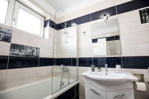 a bathroom with a sink and a shower and a mirror at Modern Condo with parking, Sibiu in Sibiu