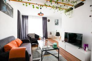 a living room with a couch and a tv at Modern Condo with parking, Sibiu in Sibiu