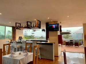 a dining room with tables and chairs and a television at Arcadia Suites - Kampala in Kampala