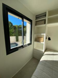 een slaapkamer met een bed en een raam met uitzicht bij STUDIO in res. LES CYCLISTES in Malaucène