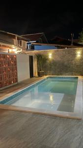 a swimming pool at night with at Pousada Casa Mariscal in Bombinhas