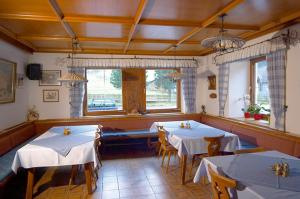 a restaurant with two tables with white table cloth at Schiederhof in Mittersill