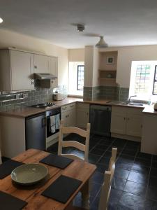 a kitchen with a wooden table and a table and chairs at Cosy Arts & Crafts Cottage with stunning views in Brecon