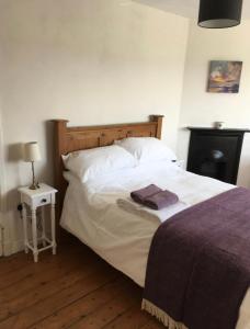 1 dormitorio con cama blanca y cabecero de madera en Cosy Arts & Crafts Cottage with stunning views, en Brecon