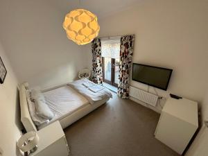 um quarto com uma cama e uma televisão de ecrã plano em 2 Bedroom Riverside Property with Roof Terrace em Stockton-on-Tees