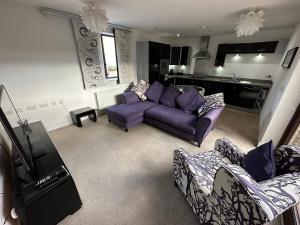 a living room with purple couches and a kitchen at 2 Bedroom Riverside Property with Roof Terrace in Stockton-on-Tees