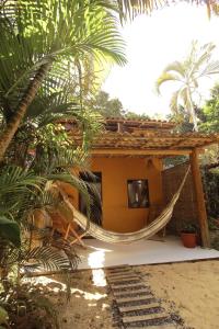 une maison avec un hamac en face de celle-ci dans l'établissement Caraiva Casa, à Caraíva