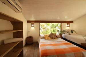 - une chambre avec 2 lits et une fenêtre dans l'établissement Caraiva Casa, à Caraíva