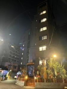 un edificio alto con un cartel en él por la noche en The garden hotel en Seúl