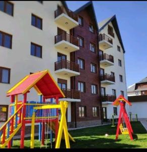 a playground in front of a large building at VILA KATALINA 1 APARTMAN MAKRIC in Zlatibor +52 photos