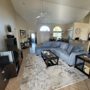 ein Wohnzimmer mit einem blauen Sofa und einem Tisch in der Unterkunft Villa Tortuga - Place to Relax in Cape Coral