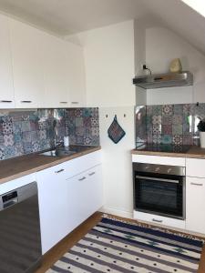 uma cozinha com armários brancos, um lavatório e um fogão em Ferienwohnung Amsel em Essen