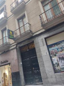 un edificio con una puerta negra y balcones en él en Hostal “ INFANTAS”, en Madrid