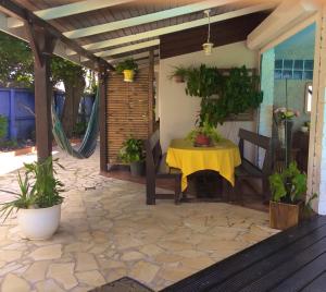 une terrasse avec une table jaune et des plantes en pot dans l'établissement AU PIPIRI LÉVÉ, à Schœlcher