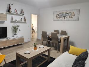 APARTAMENTO ESTEL في لا سو دي أورغل: غرفة معيشة مع طاولة وغرفة طعام